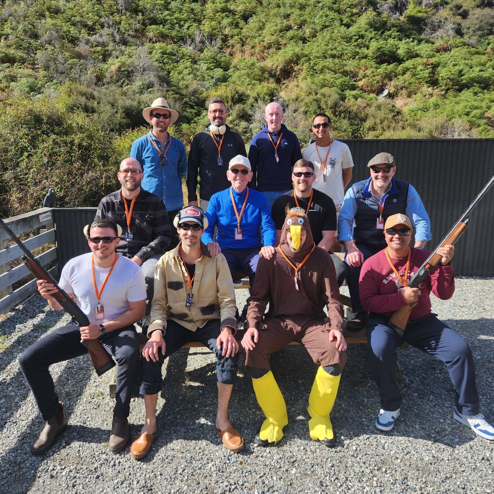 Team enjoying outdoor clay shooting experience with scenic Queenstown backdrop