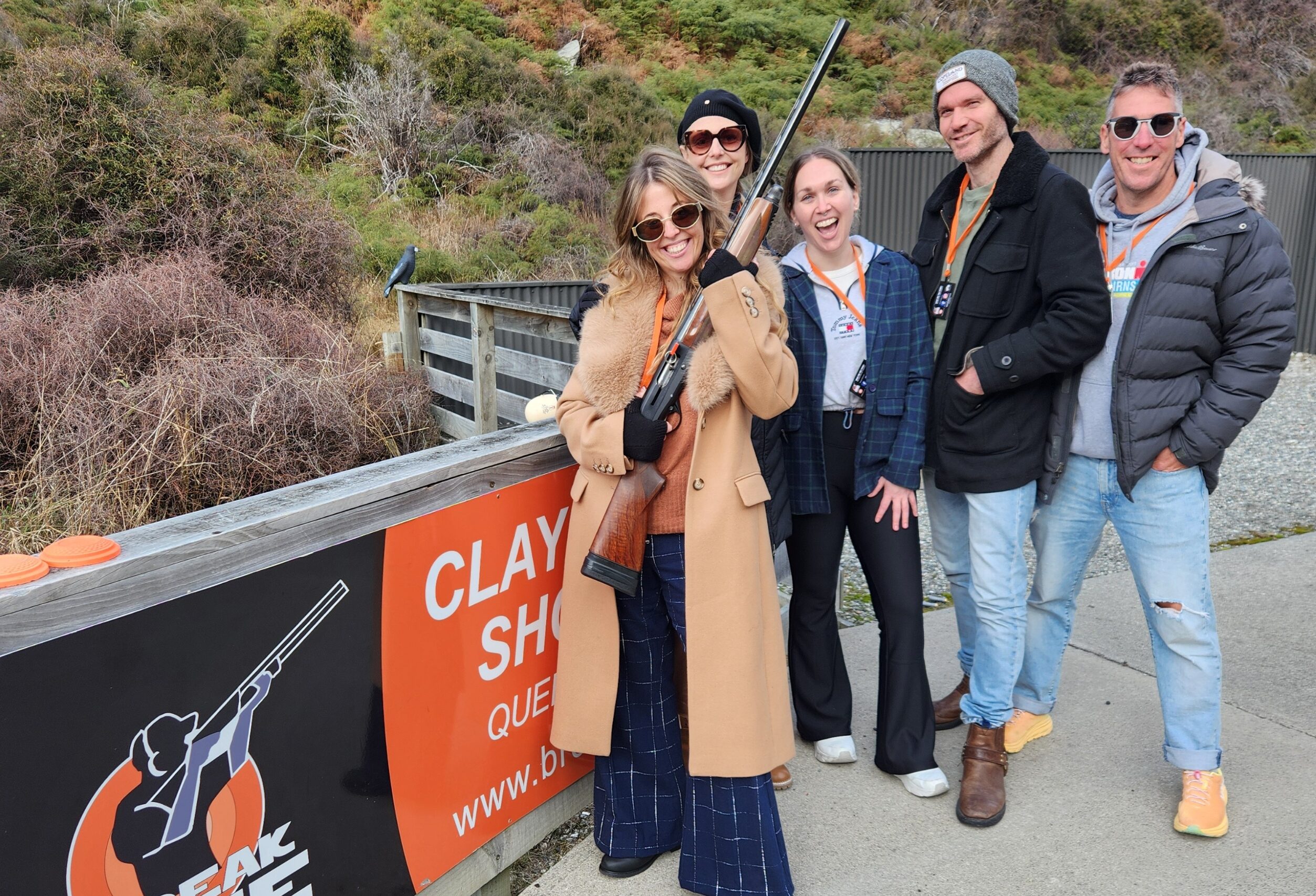 Group of friends posing with a shotgun at Break One Clay Target Experience in Queenstown, enjoying a fun and safe shooting session suitable for all skill levels.