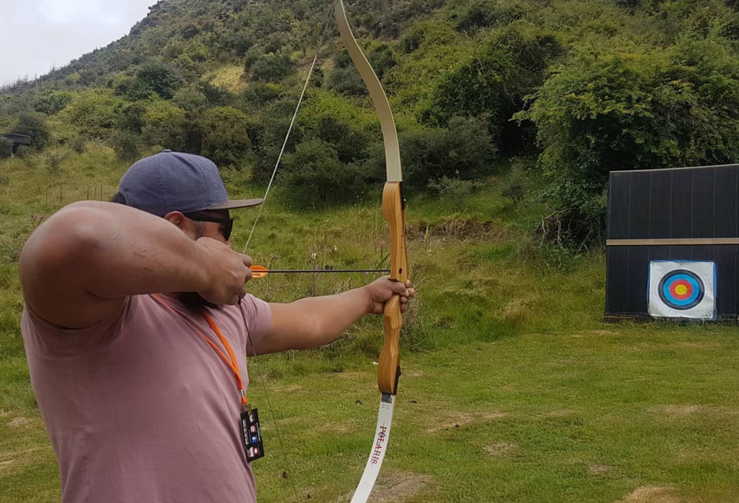 Guest drawing a bow at Break One archery range in Queenstown.